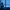 Person sitting by a window on a snowy winter night, reflecting quietly in a blue-toned room.
