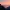 Person sitting on a cliff at sunset overlooking a calm river and mountains