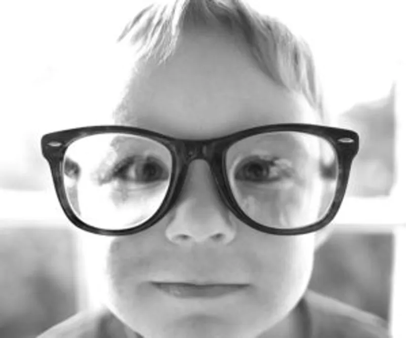 Close-up of a face wearing oversized glasses in black and white
