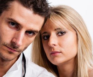 Two adults leaning close together and looking toward the camera