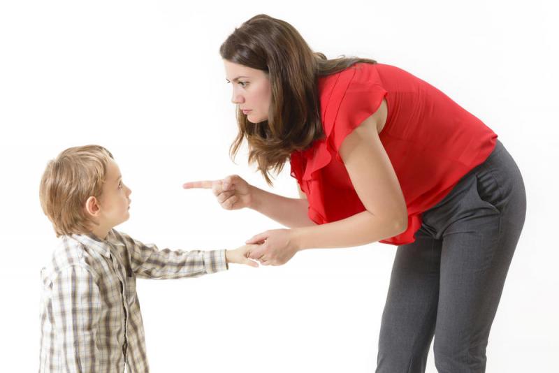 Adult points toward a child while holding the child's hand