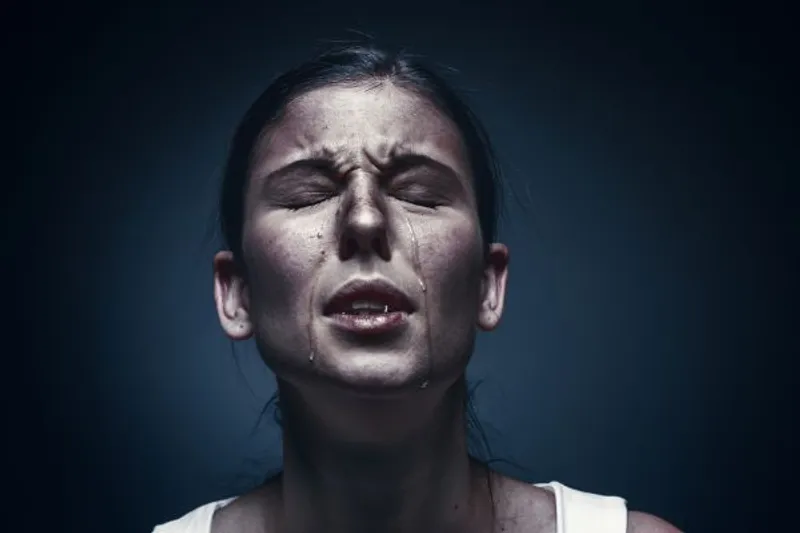 Close-up of a person with eyes closed and tears running down their face