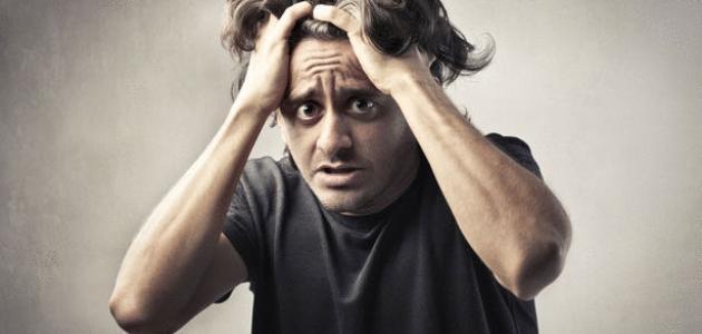 Person grips their hair with both hands while looking upward