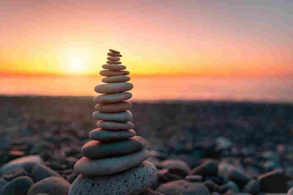 Smooth stones stacked on a rocky beach at sunset