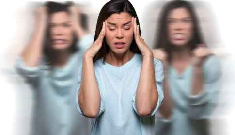 Person pressing both hands to their temples, with blurred duplicates on either side