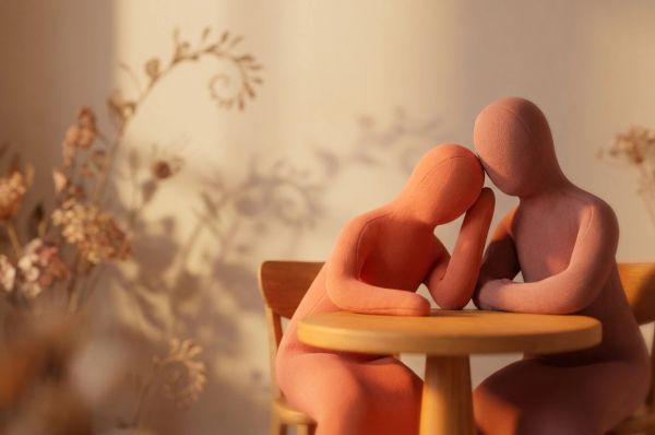 two human figures sitting at a table with gentle glow filling the room