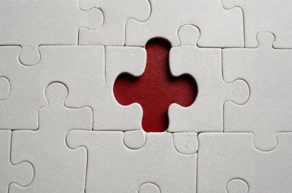 Missing puzzle piece reveals red center beneath white pieces symbolizing love’s gap