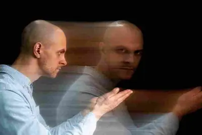 Seated person with two overlapping, motion-blurred copies of their body