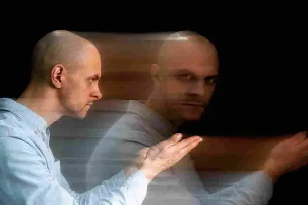 Seated person with two overlapping, motion-blurred copies of their body