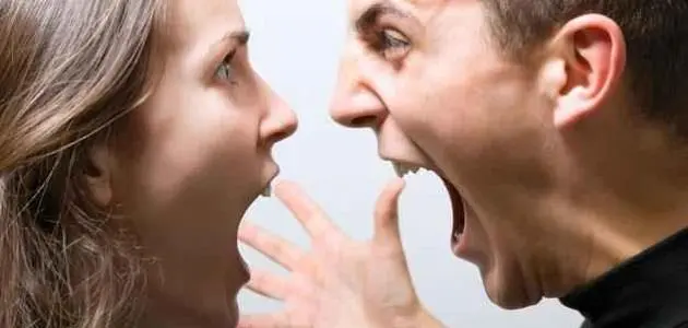 Two people face each other at close range with open mouths and a raised hand