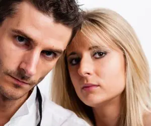 Two adults leaning close together and looking toward the camera