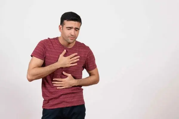 Person with eyes closed holds one hand to the chest and one to the abdomen