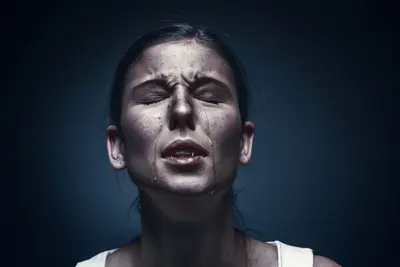 Close-up of a person with eyes closed and tears running down their face